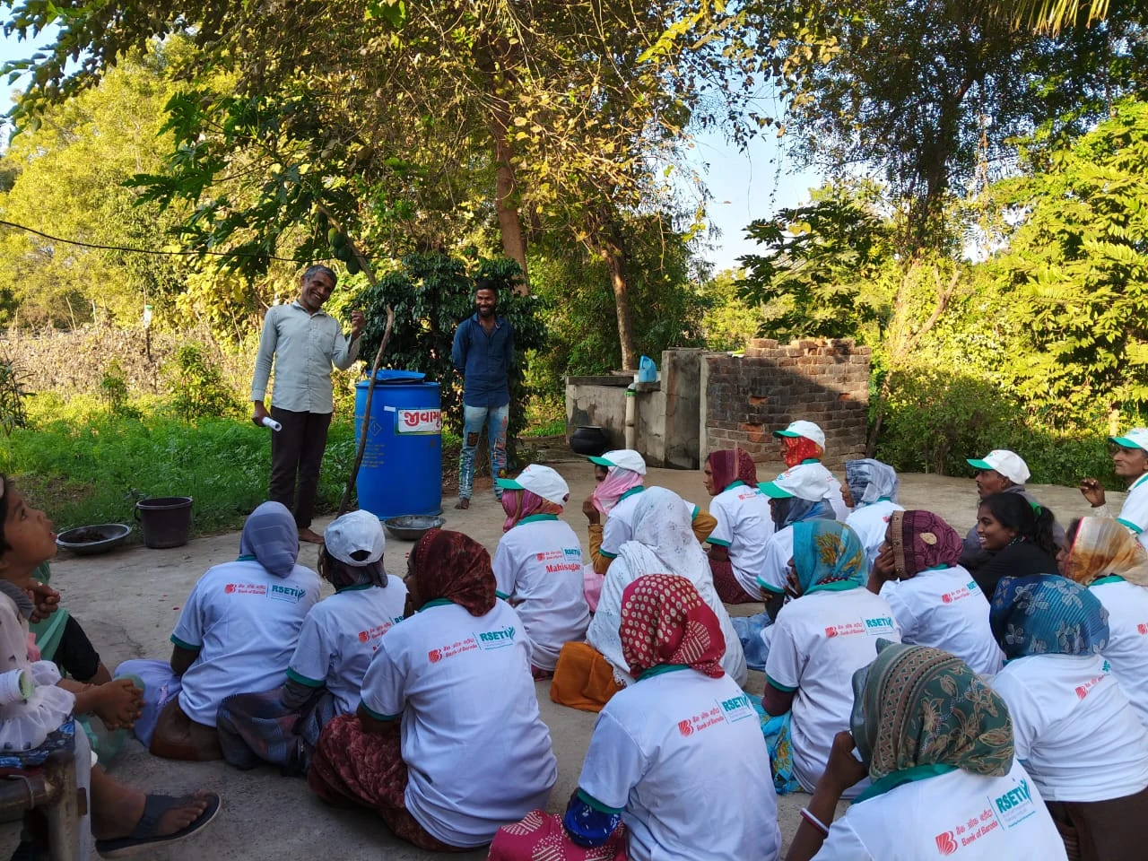 A women-focused farmer training session taking place outdoors in a village setting